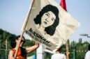 Ilustrasi gerakan buruh Indonesia, peserta aksi mengibarkan bendera bergambar Marsinah, ikon perjuangan buruh. (Foto: Wikimedia Commons, CC BY 2.0)