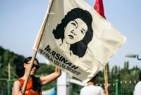 Ilustrasi gerakan buruh Indonesia, peserta aksi mengibarkan bendera bergambar Marsinah, ikon perjuangan buruh. (Foto: Wikimedia Commons, CC BY 2.0)