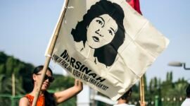 Ilustrasi gerakan buruh Indonesia, peserta aksi mengibarkan bendera bergambar Marsinah, ikon perjuangan buruh. (Foto: Wikimedia Commons, CC BY 2.0)